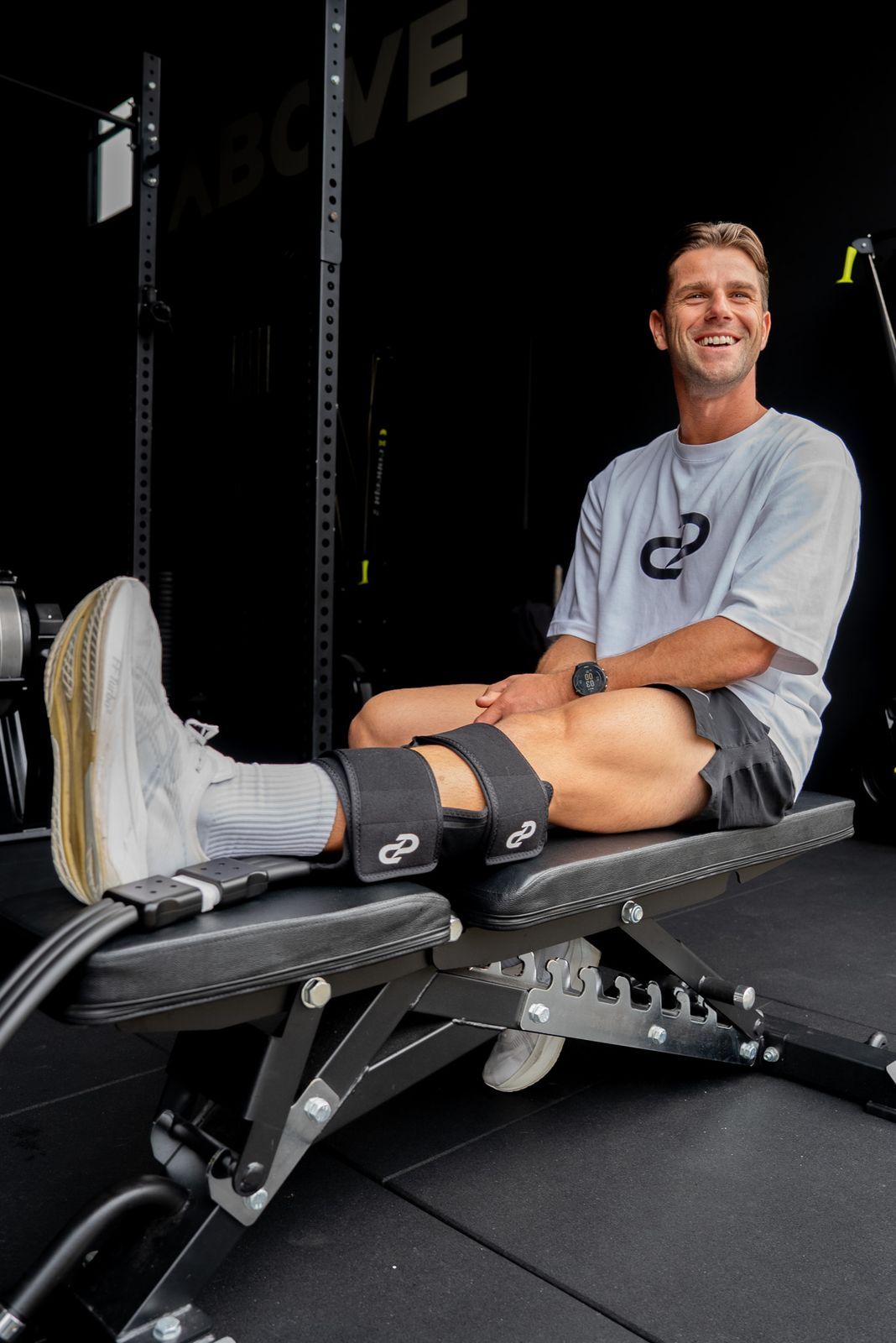 Athlete relaxing with Pulse One calf wrap in a gym